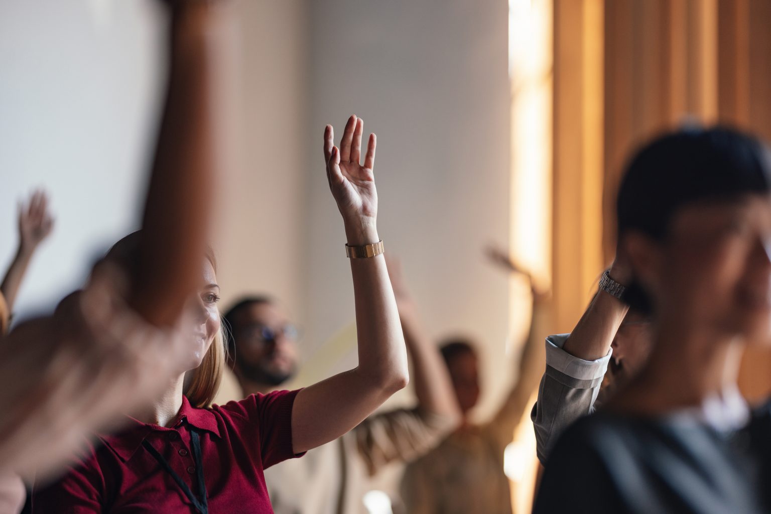 An audience with raised hands at a live event
