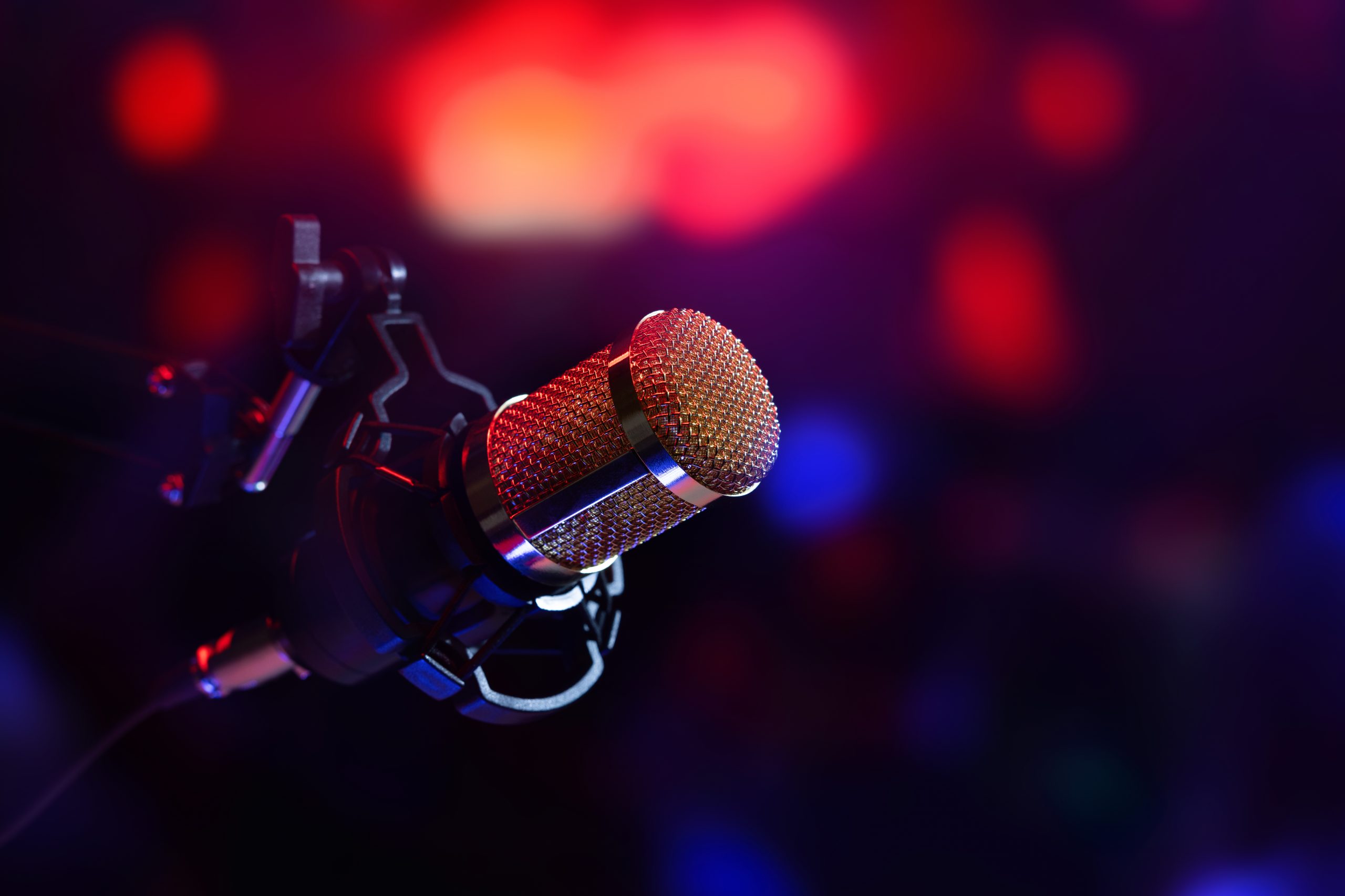 A studio microphone under stage lighting