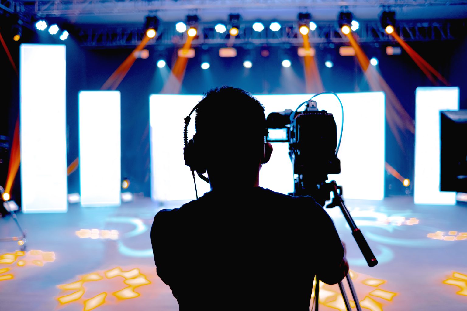 A camera operator framing a live event stage