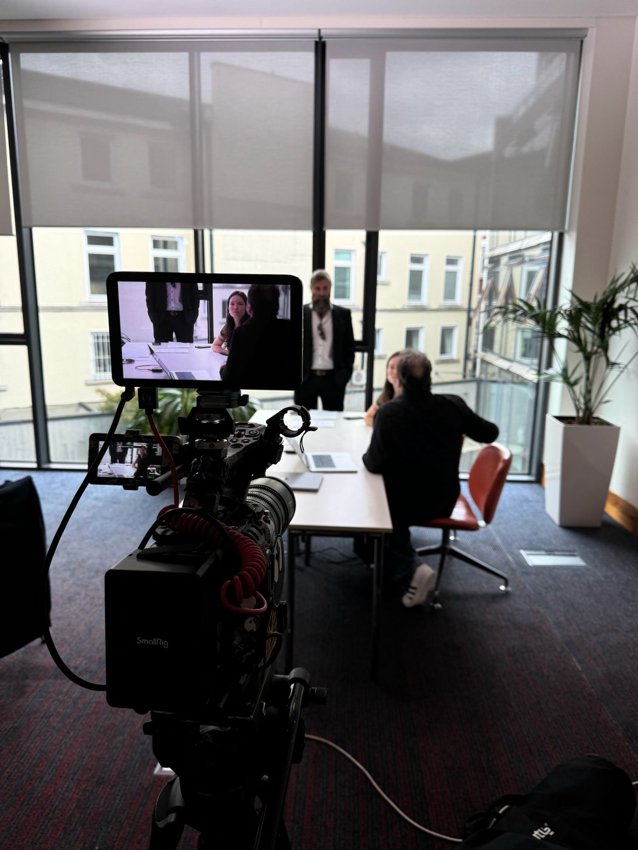 Actor at a desk framed on the camera monitor during the Be the Boss shoot